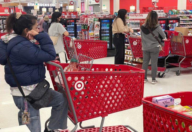 Customers wait in line to make purchases at a Target store on December 14, 2023 in Daly City, California. According to a report by the Commerce Department, consumer retial sales increased by 0.3% percent in November compared to the prior month.