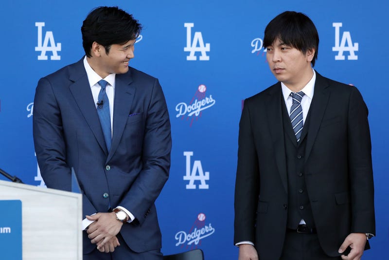  Shohei Ohtani speaks with his interpreter Ippei Mizuhara prior to being introduced by the Los Angeles Dodgers at Dodger Stadium on December 14, 2023 in Los Angeles, California. 