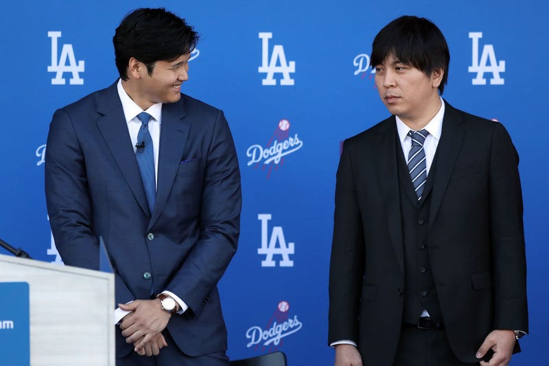 Shohei Ohtani speaks with his interpreter Ippei Mizuhara prior to being introduced by the Los Angeles Dodgers at Dodger Stadium on December 14, 2023 in Los Angeles, California. 