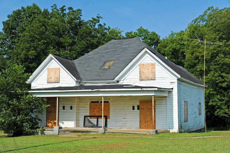 Abandoned house with boarded up windows.