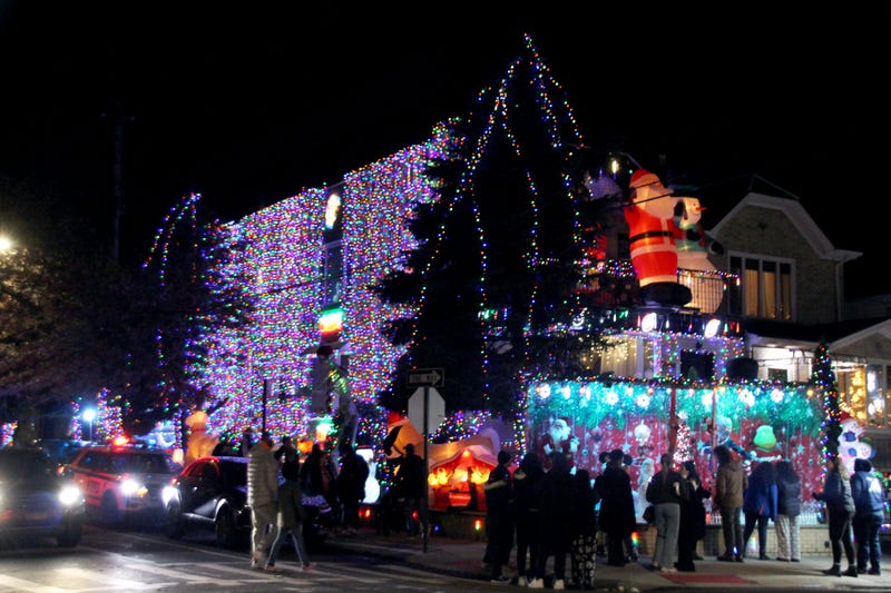 People pack the street to see a home completely covered in lights and displays