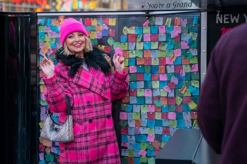 A person poses with their wish at the New Year's Eve Wishing Wall in Times Square on Dec. 20, 2023 in New York City.