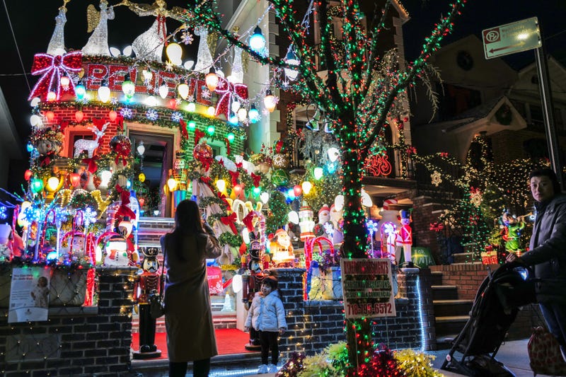 Visitors take photos outside a house in Dyker Heights on Dec. 20, 2023