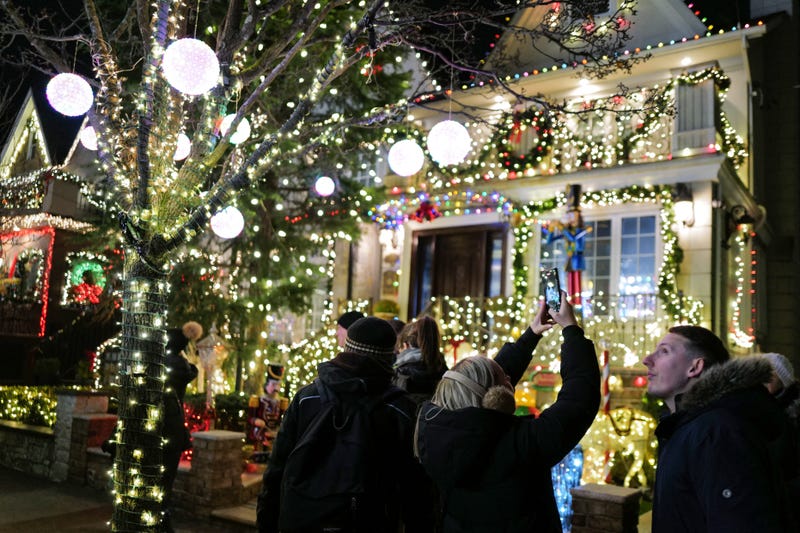 Visitors snap photos of homes in Dyker Heights on Dec. 20, 2023