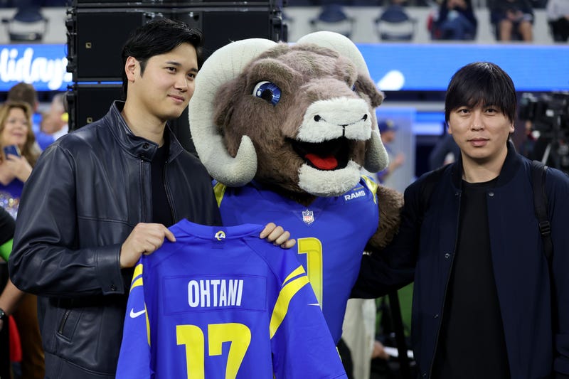 (L-R) Shohei Ohtani of the Los Angeles Dodgers poses with the Los Angeles Rams mascot and interpreter Ippei Mizuhara prior to the game between the New Orleans Saints and the Los Angeles Rams at SoFi Stadium on December 21, 2023 in Inglewood, California.