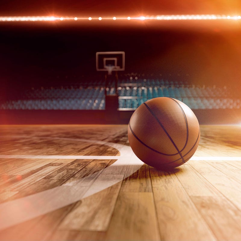 A basketball sits an an empty court