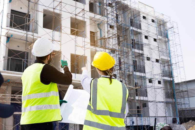 Construction workers pointing at site