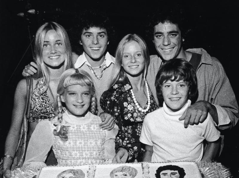 The Brady Bunch' pose with a cake celebrating the show's 100th episode, circa 1973. (L-R): Maureen McCormick, Susan Olsen, Christopher Knight, Eve Plumb, Barry Williams and Mike Lookinland
