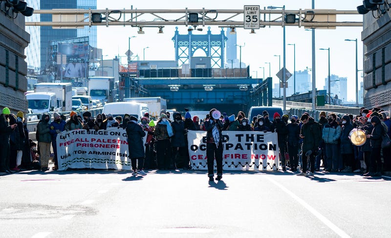 Pro-Palestinian protesters are pictured blocking traffic on the Manhattan Bridge
