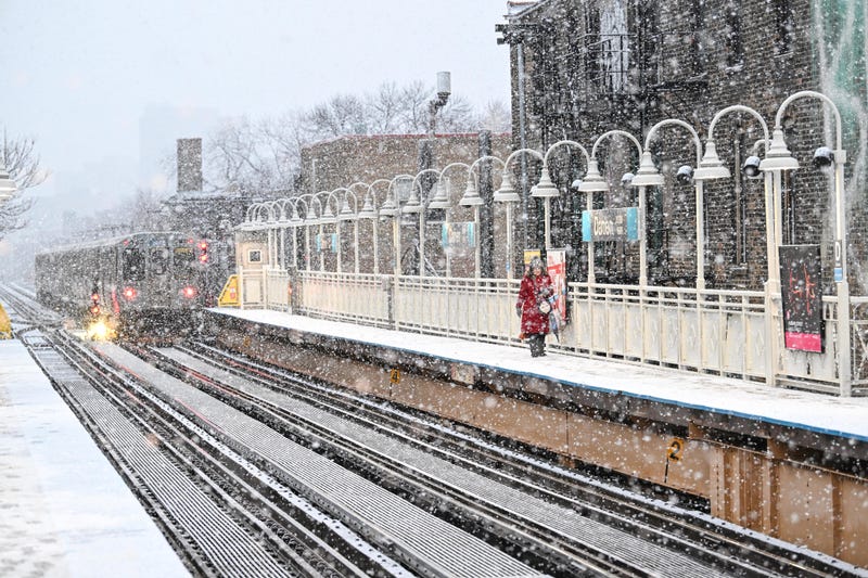 A commuter walks on the platform at the CTA Damen Blue Line station as it snows.