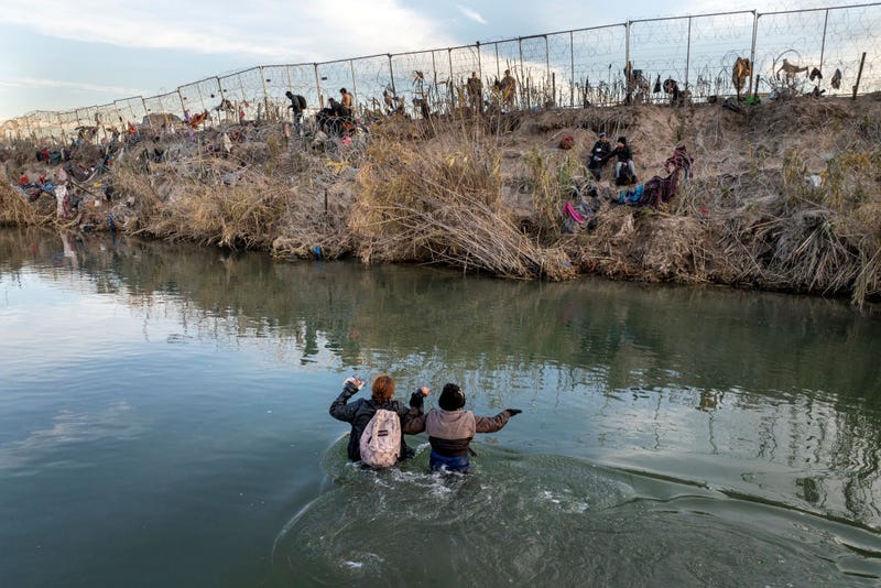 In an aerial view, immigrants wade across the Rio Grande while crossing from Mexico into the United States on January 07, 2024 in Eagle Pass, Texas. According the a new report released by U.S. Department of Homeland Security, some 2.3 million migrants, mostly from families seeking asylum, have been released into the U.S. under the Biden Administration since 2021.