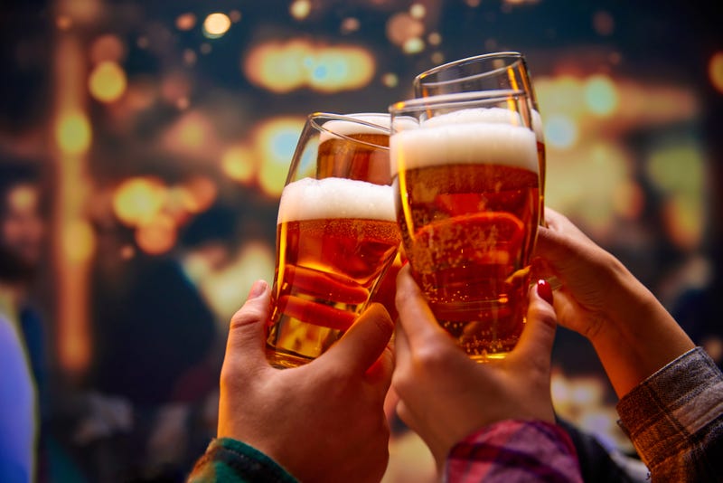 People raise their beer glasses to cheers.