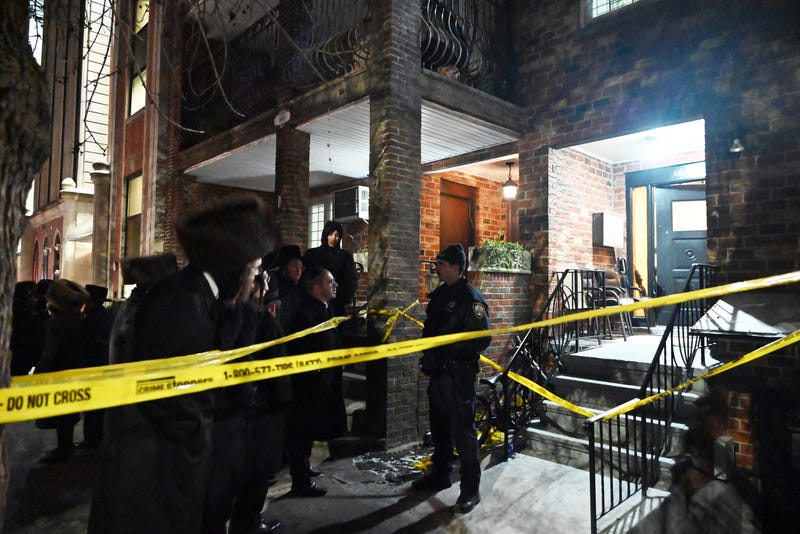 A police officer guards a residential building on 45th Street where a man allegedly stabbed his parents to death on Jan. 20, 2024