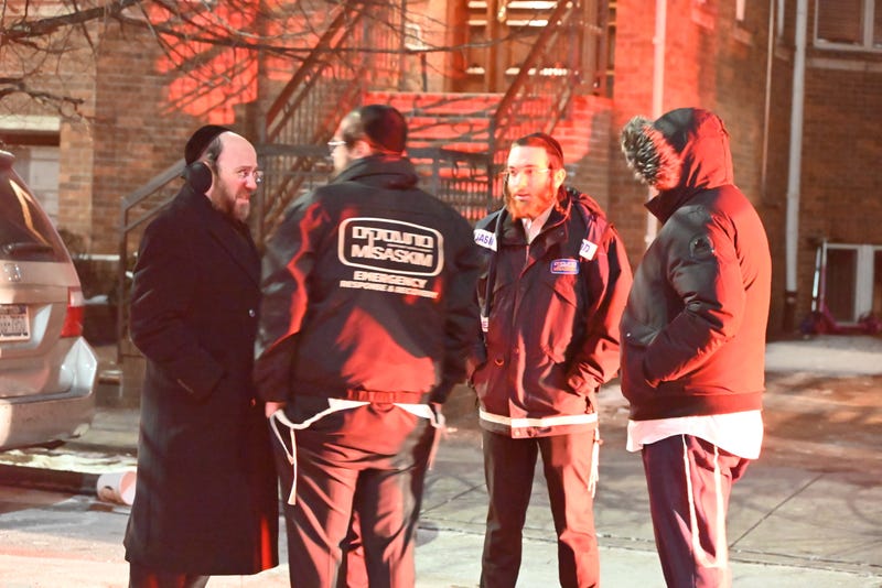 Emergency service workers speak at the scene of the fatal double stabbing on Jan. 20, 2024
