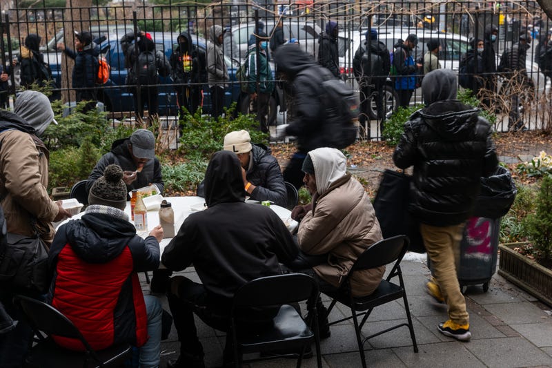 People, mostly newly arrived migrants, receive an afternoon meal from Trinity Services and Food For the Homeless, across from Tompkins Square Park on January 24, 2024