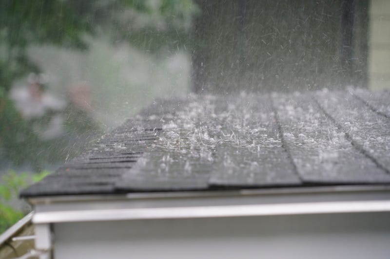 Close up of rain from a storm hitting a roof. 