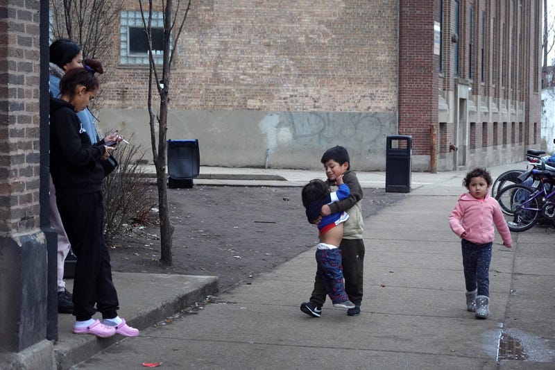 Families spend time together in front of a migrant shelter in the West Loop neighborhood on Jan. 30, 2024, in Chicago.