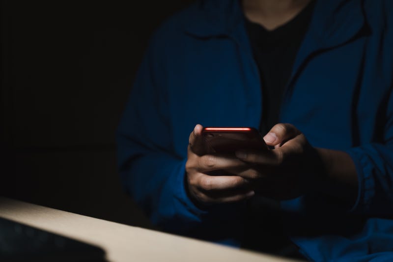 Man using smartphone in a dark room