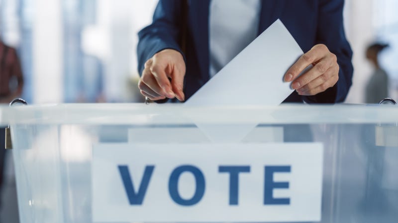 A man drops his vote into a ballot box