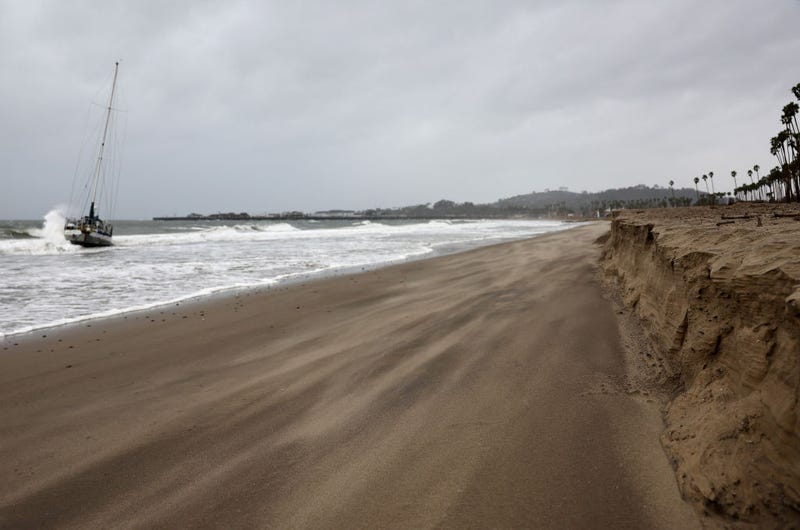 Sand blows as a wave hits a boat which washed ashore as a powerful long-duration atmospheric river storm, the second in less than a week, impacts California on February 4, 2024 in Santa Barbara, California. The storm is delivering potential for widespread flooding, landslides and power outages while dropping heavy rain and snow across the region.