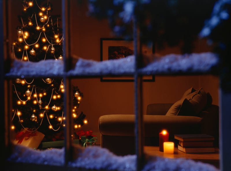Snow on window with Christmas tree in living room