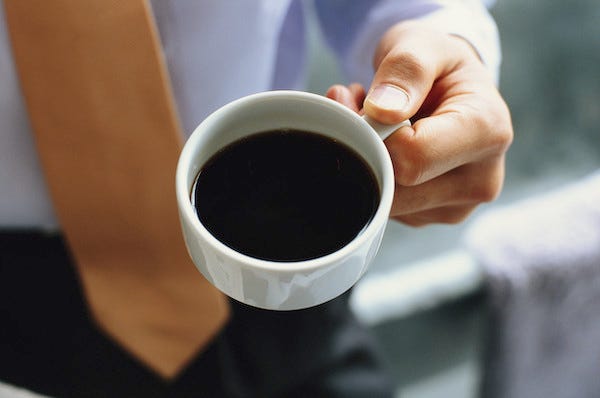Businessman holding a cup of black coffee