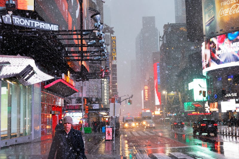 People walk along Times Square amid a winter storm on February 13, 2024
