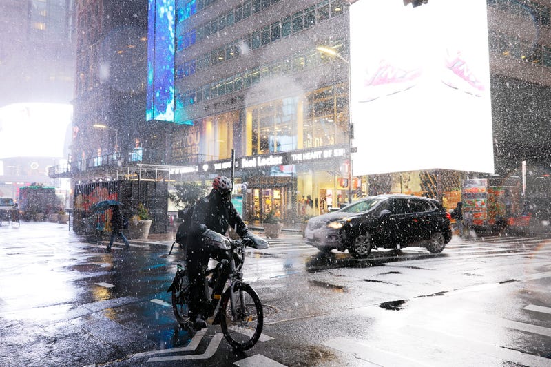 A delivery person rides his bike in Times Square amid a winter storm on February 13, 2024