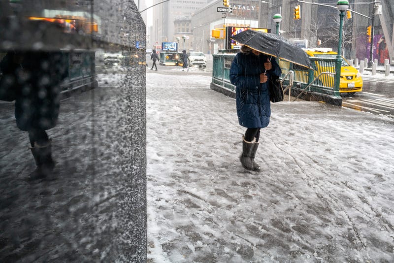 People walk through the blowing snow in Manhattan as a large winter storm makes its way across the area on February 13, 2024