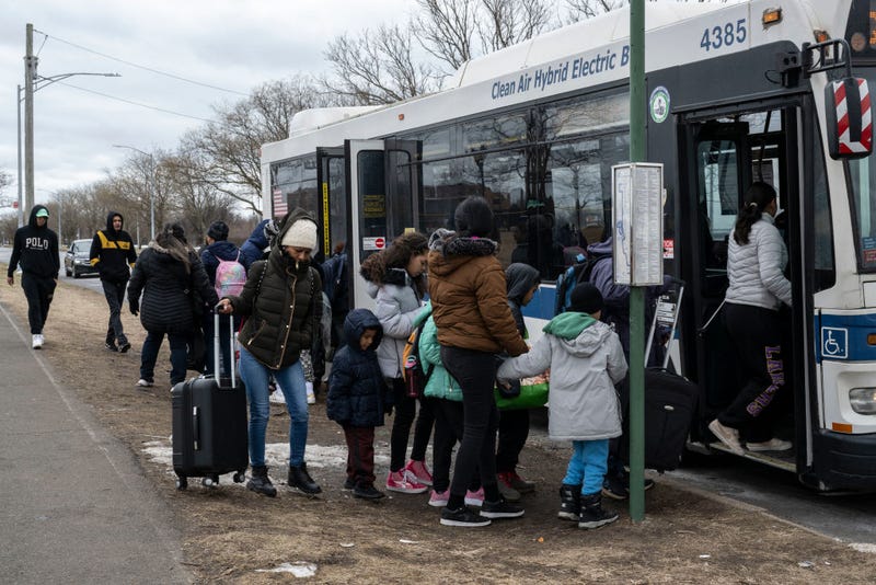 Recently arrived migrants get on a bus outside Floyd Bennett Field shelter on Feb. 21, 2024.