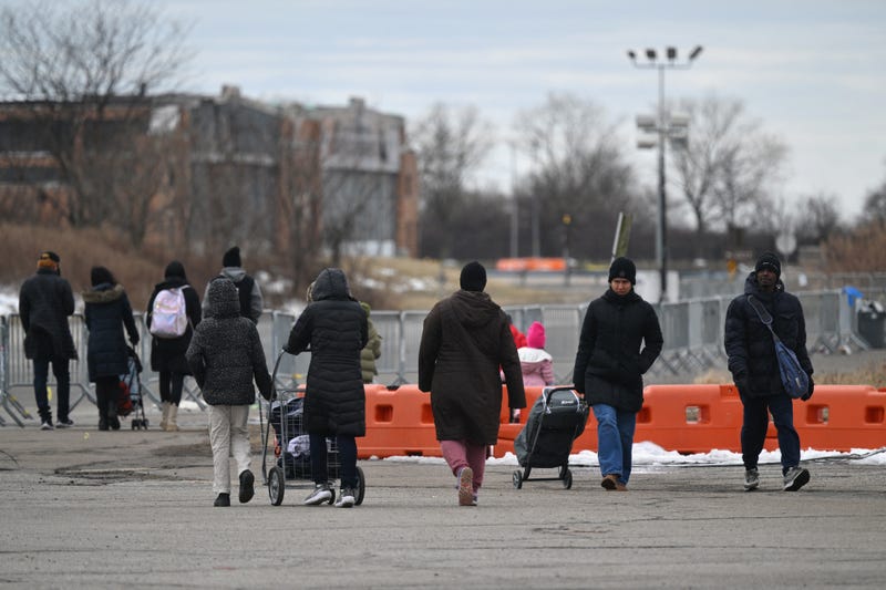 Recently arrived migrants walk outside Floyd Bennett Field shelter on February 21, 2024