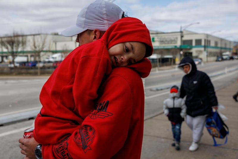 Angel Cardena, 25, holds his 3-year-old son Yulian Cardena outside a migrant shelter on the Lower West Side on Wednesday, Feb. 28, 2024, in Chicago.