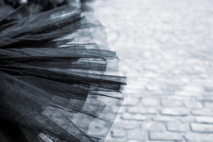 Detail of a Black tutu laying on the cobblestone