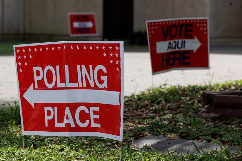 A vote here and polling location sign on outside a polling place