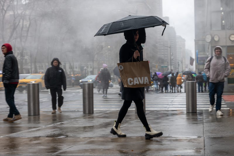 People walk through the rain in Midtown Manhattan in March