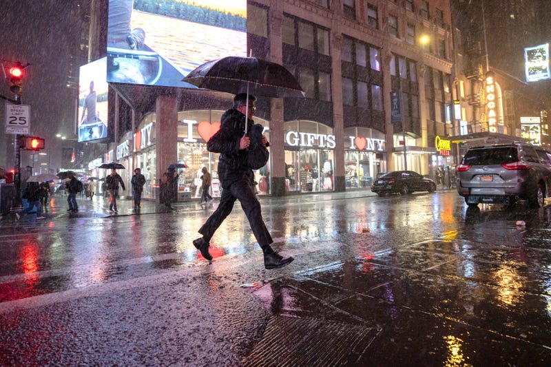 New Yorkers walk through Times Square during a rain storm on March 6, 2024