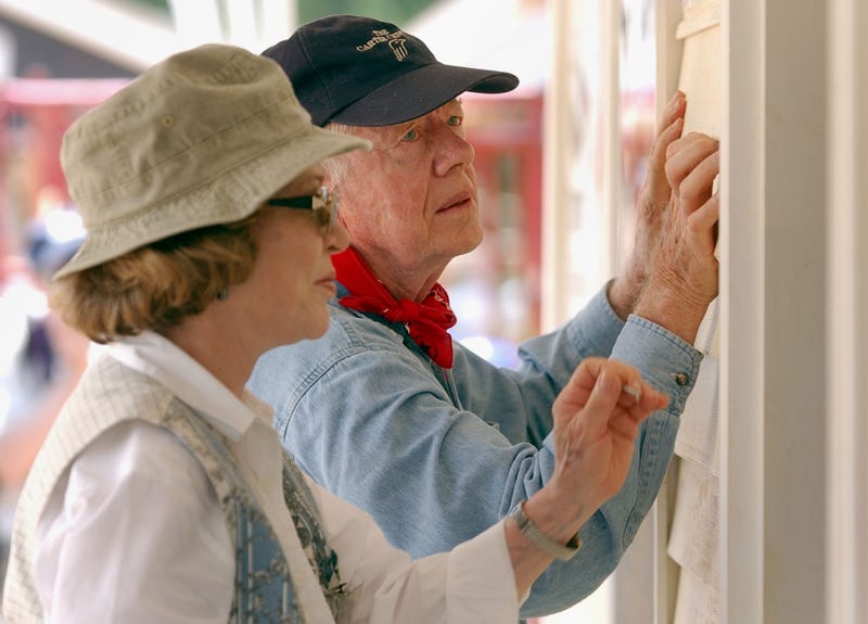 Former U.S. President Jimmy Carter and his wife Rosalyn attach siding to the front of a Habitat for Humanity home being built June 10, 2003 in LaGrange, Georgia. More than 90 homes are being built in LaGrange; Valdosta, Georgia; and Anniston, Alabama by volunteers as part of Habitat for Humanity International's Jimmy Carter Work Project 2003.