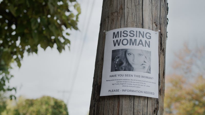 n advertisement for the missing woman hangs on a wooden pole.