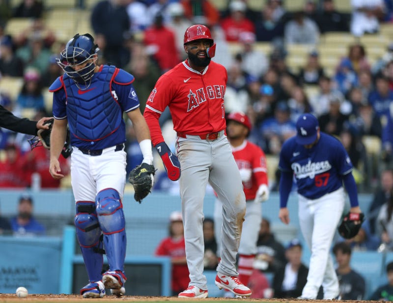 Jo Adell #7 of the Los Angeles Angels reacts to his run behind Austin Barnes #15 of the Los Angeles Dodgers, from a Jake Marisnick #10 double to trail 4-3 in the seventh inning, during a preseason game at Dodger Stadium on March 24, 2024 in Los Angeles, California.