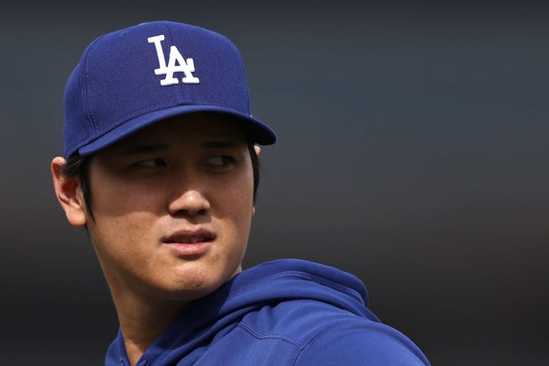 Shohei Ohtani #17 of the Los Angeles Dodgers reacts as he warms up prior to a game against the Los Angeles Angels at Dodger Stadium on March 25, 2024 in Los Angeles, California.