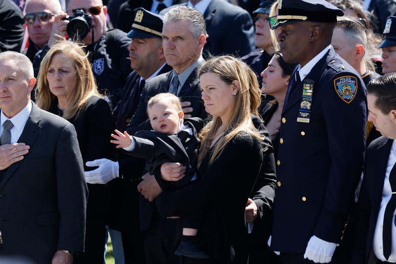 Stephanie Diller, the widow of NYPD officer Jonathan Diller, carries her son Ryan at the funeral of her husband at St. Rose of Lima R.C. Church on March 30, 2024 in Massapequa, New York