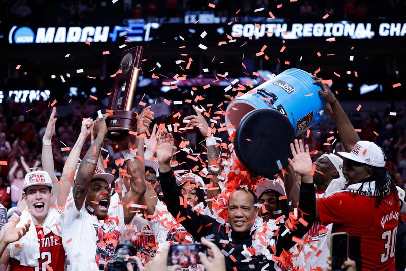 Head coach Kevin Keatts of the North Carolina State Wolfpack is doused with confetti as players celebrate after the Wolfpack defeated the Duke Blue Devils