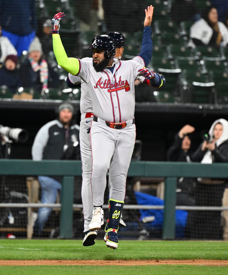 Marcell Ozuna #20 of the Atlanta Braves is congratulated by third base coach Matt Tuiasosopo #89 of the Atlanta Braves following a home run during the seventh inning of a game against the Chicago White Sox at Guaranteed Rate Field