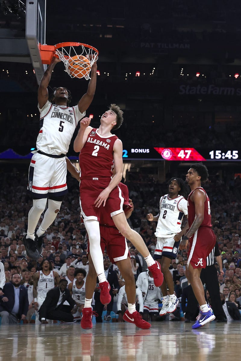 Stephon Castle #5 of the Connecticut Huskies dunks the ball past Grant Nelson #2 of the Alabama Crimson Tide in the second half in the NCAA Men's Basketball Tournament Final Four semifinal game at State Farm Stadium on April 06, 2024 in Glendale, Arizona.