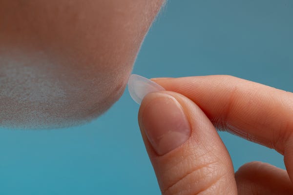 Girl using an acne patch on her face