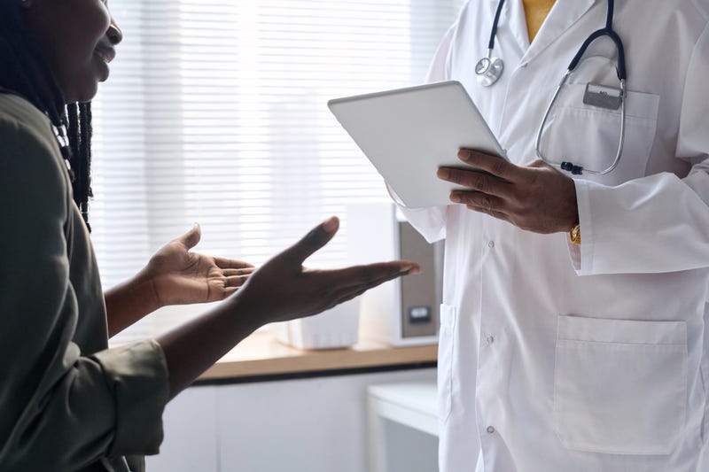 Close-up of woman gesturing and talking to doctor