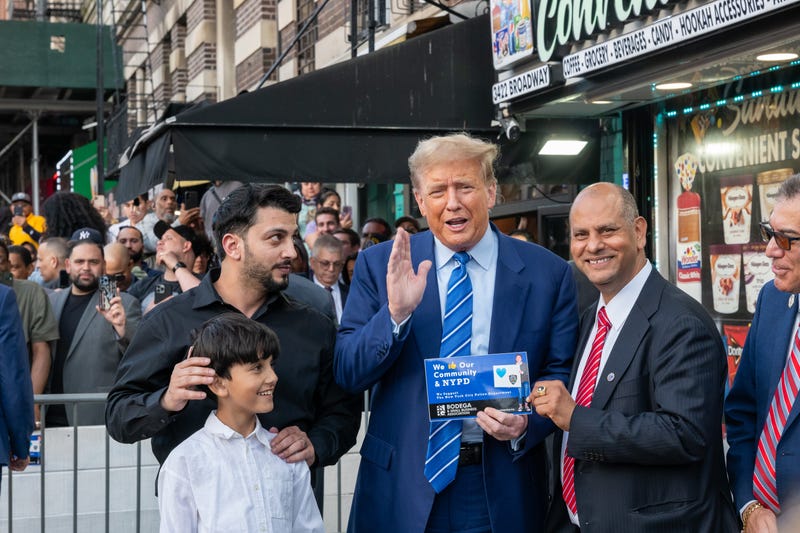 Former president Donald Trump stands with local politicians and bodega workers as he visits a bodega store in upper Manhattan where a worker was assaulted by a man in 2022 and ended up killing him in an ensuing fight on April 16, 2024