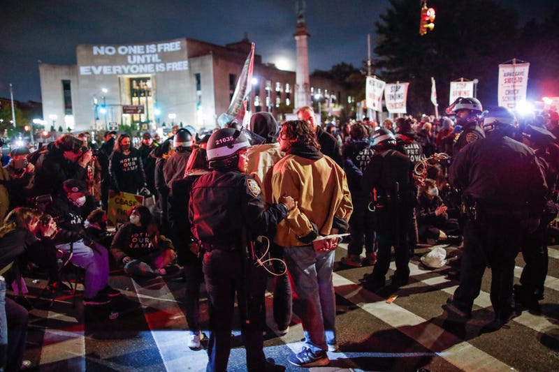 Police officers detain people as protesters block the street near the home of US Senate Majority Leader Chuck Schumer in Brooklyn on April 23, 2024