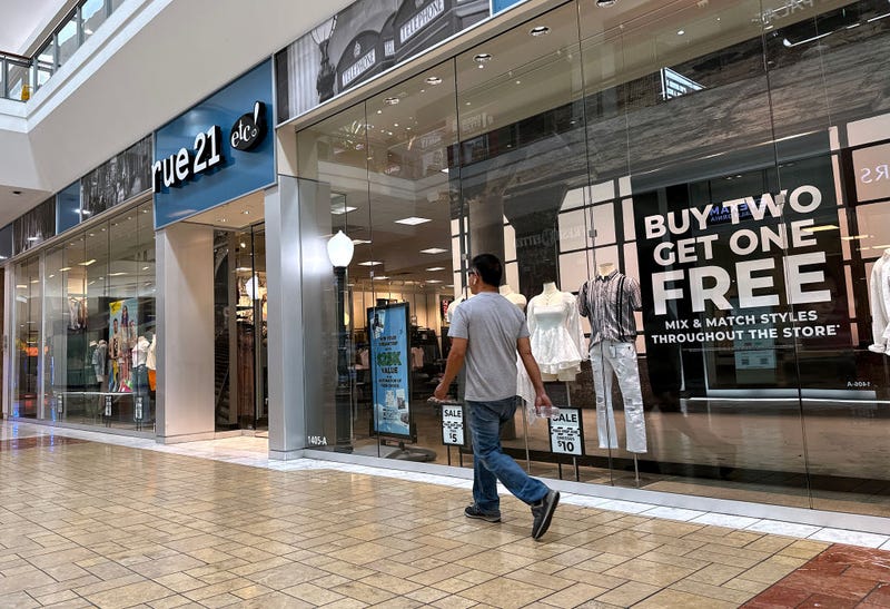 A shopper walks by a rue21 store