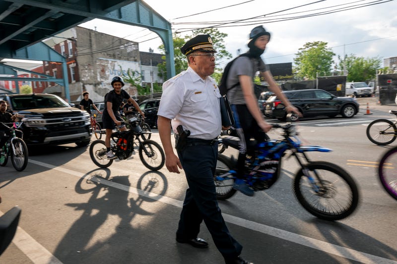Philadelphia Police Commissioner Kevin Bethel walks through Kensington, flanked by bicyclists.